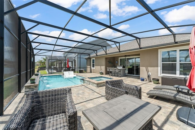 view of swimming pool featuring glass enclosure, a pool with connected hot tub, an outdoor kitchen, and a patio