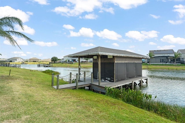view of dock featuring a lawn, a residential view, and a water view