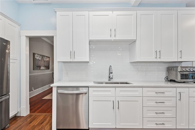 404 N Clara Ave, Deland, FL 32720 - kitchen with stainless steel appliances, light countertops, dark wood-type flooring, backsplash, and white cabinets