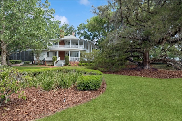 404 N Clara Ave, Deland, FL 32720 - victorian-style house featuring a balcony, a chimney, covered porch, and a front yard