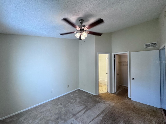 unfurnished bedroom featuring a spacious closet, visible vents, carpet floors, a closet, and baseboards