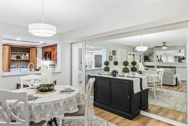 dining area with light wood finished floors, ceiling fan, and recessed lighting