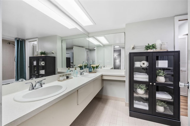 bathroom with double vanity and baseboards
