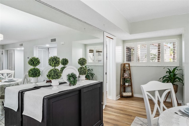 dining space with light wood finished floors and baseboards