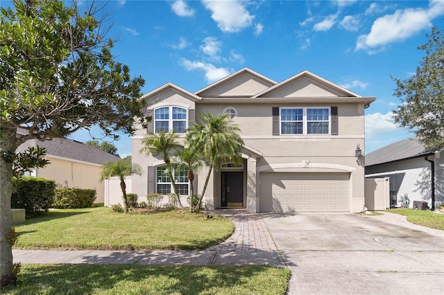 view of front of house featuring an attached garage, a front yard, driveway, and stucco siding