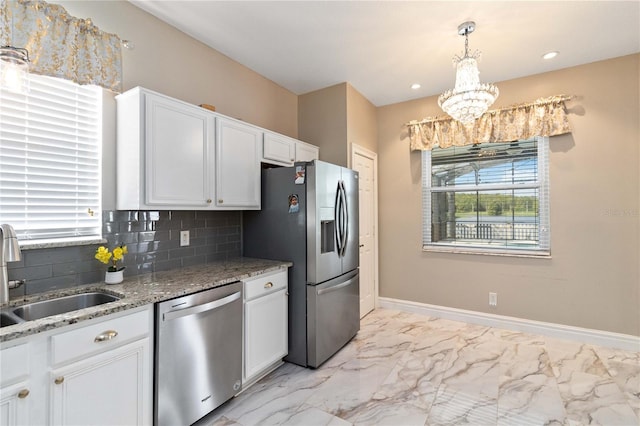 kitchen featuring an inviting chandelier, a sink, stainless steel appliances, and a healthy amount of sunlight