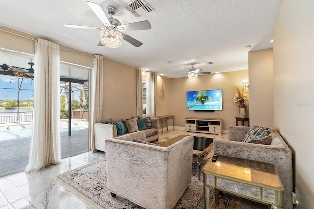 living room featuring visible vents, a ceiling fan, a textured ceiling, and marble finish floor