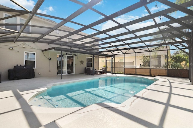 view of swimming pool featuring a patio, glass enclosure, a ceiling fan, and a fenced in pool