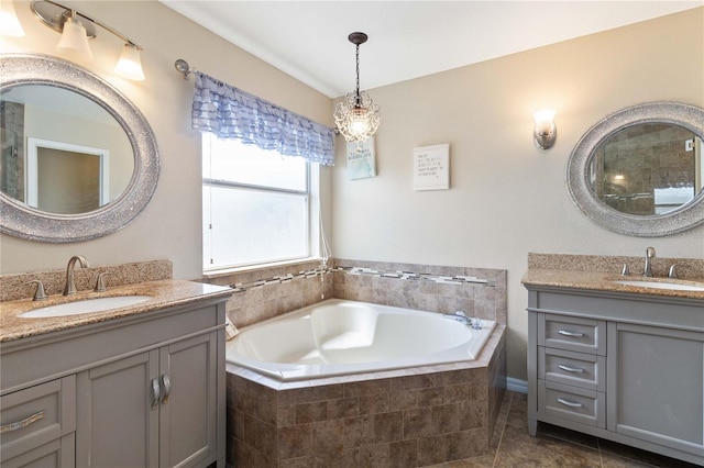bathroom featuring two vanities, a bath, and a sink