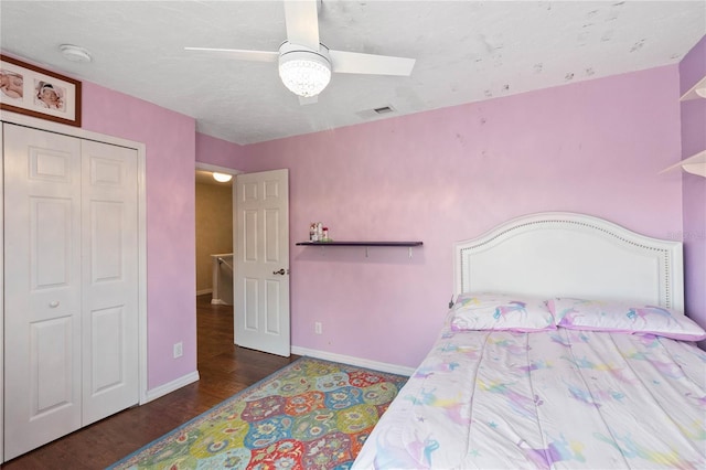 bedroom featuring visible vents, a closet, baseboards, wood finished floors, and a ceiling fan