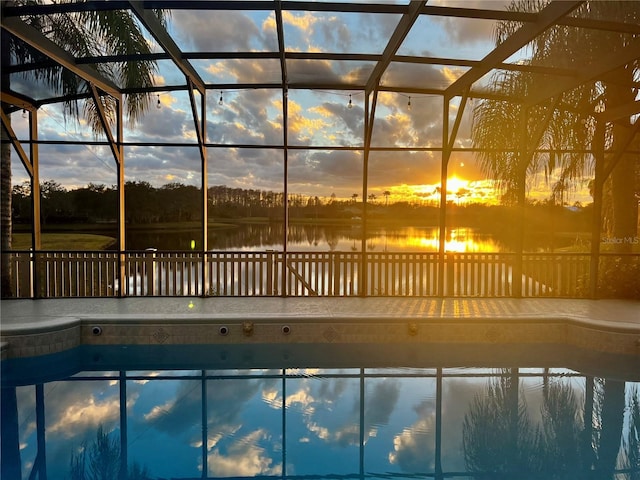 pool at dusk featuring a water view and an outdoor pool