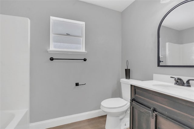full bathroom with vanity, toilet, baseboards, wood finished floors, and  shower combination