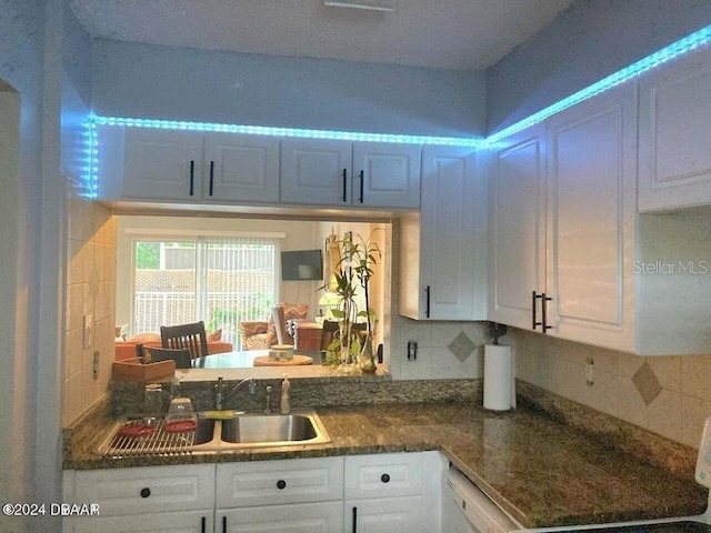 145 N Halifax Ave Unit 205, Daytona Beach, FL 32118 - kitchen with a sink, white cabinetry, and tasteful backsplash
