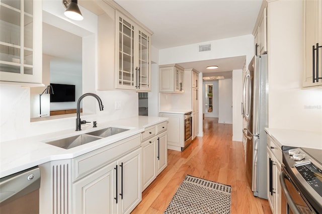 kitchen with stainless steel appliances, light countertops, visible vents, and a sink