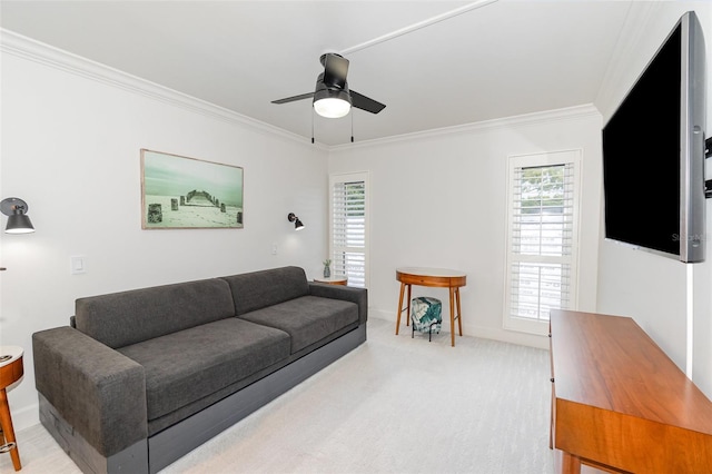 living area with a ceiling fan, light carpet, crown molding, and baseboards