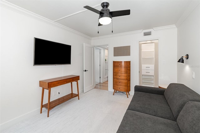 living area with visible vents, a ceiling fan, light colored carpet, and ornamental molding