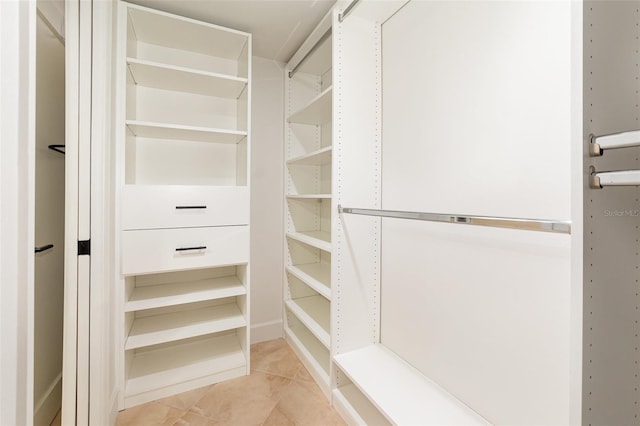 spacious closet with light tile patterned floors