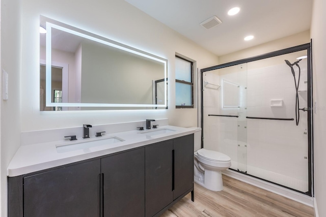 full bathroom with wood finished floors, a sink, and a stall shower