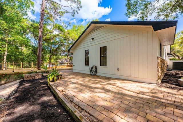 rear view of house featuring cooling unit, a patio, and fence