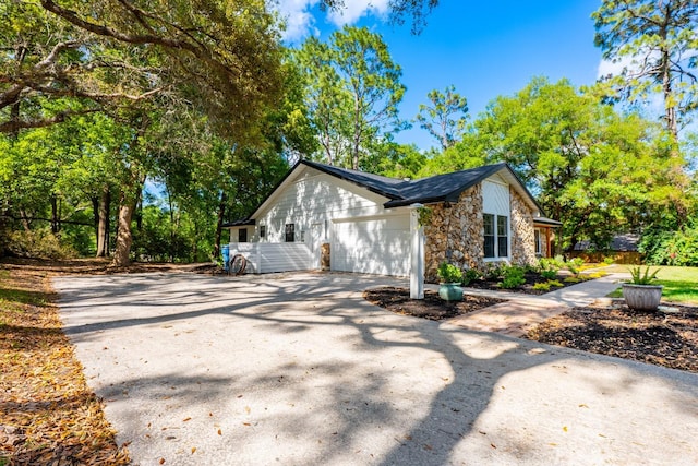 view of property exterior with stone siding, concrete driveway, and a garage