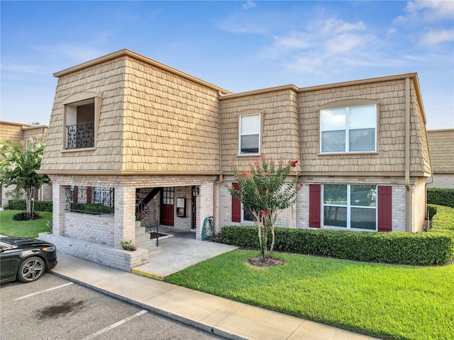 200 Saint Andrews Blvd Unit 2306, Winter Park, FL 32792 - view of property with mansard roof, a front lawn, uncovered parking, and brick siding