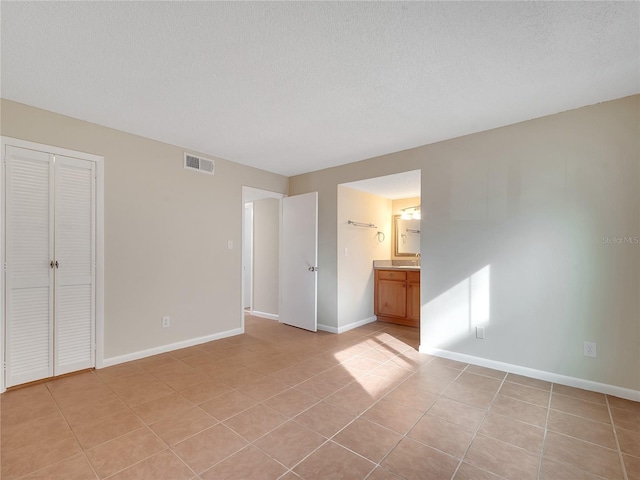 200 Saint Andrews Blvd Unit 2306, Winter Park, FL 32792 - unfurnished bedroom featuring light tile patterned floors, a closet, and a textured ceiling