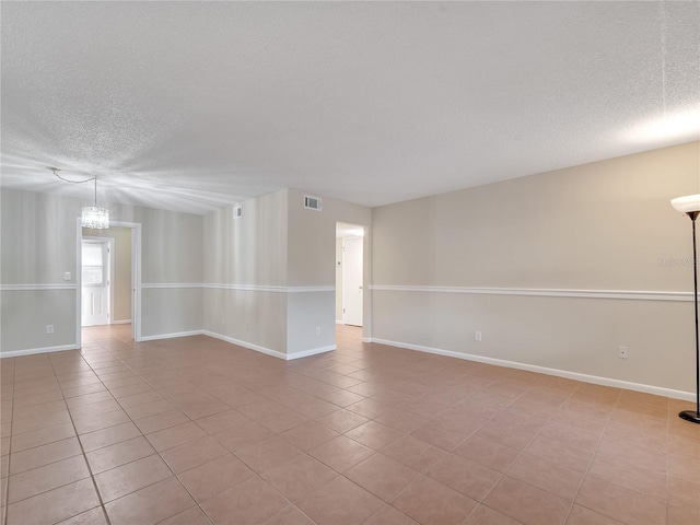 200 Saint Andrews Blvd Unit 2306, Winter Park, FL 32792 - spare room with a textured ceiling, light tile patterned floors, and a chandelier