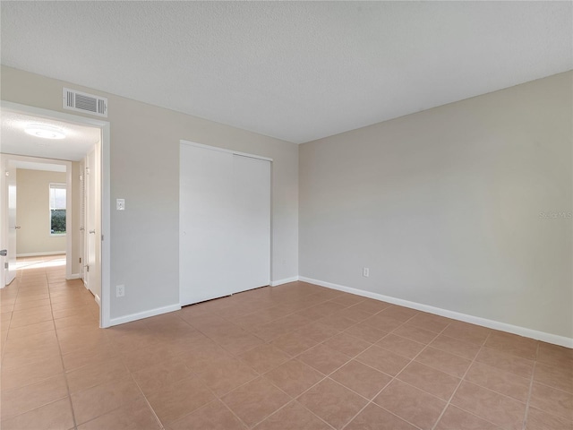 200 Saint Andrews Blvd Unit 2306, Winter Park, FL 32792 - unfurnished bedroom featuring tile patterned flooring, a textured ceiling, and a closet