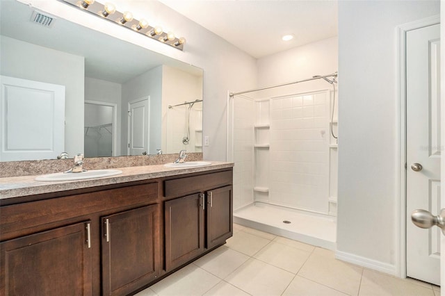 full bathroom with visible vents, a sink, tile patterned floors, and tiled shower