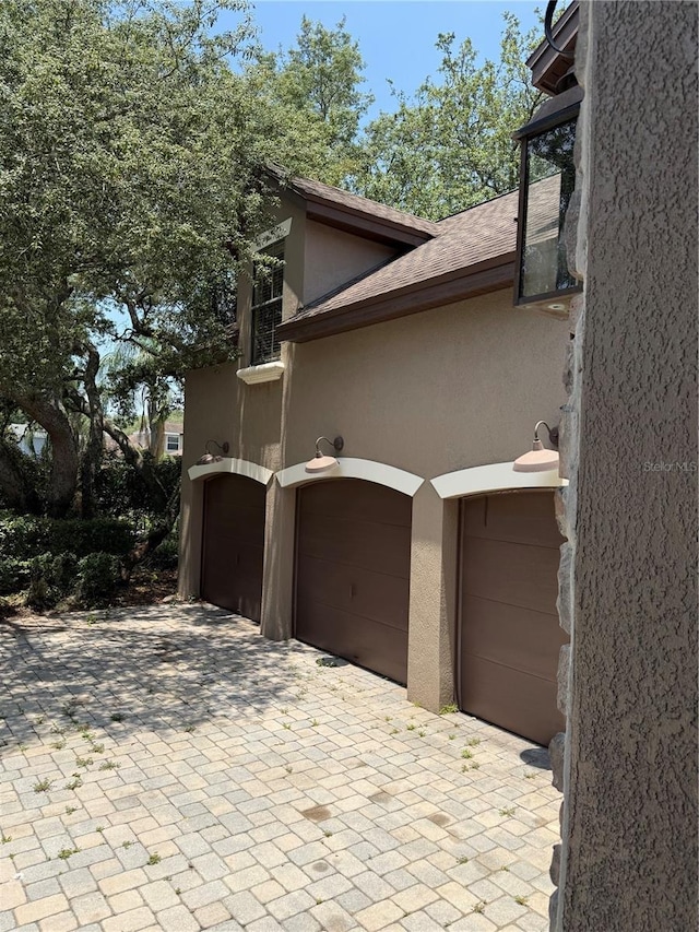 708 Palenci Ct, Winter Springs, FL 32708 - view of side of property with stucco siding, a garage, and decorative driveway