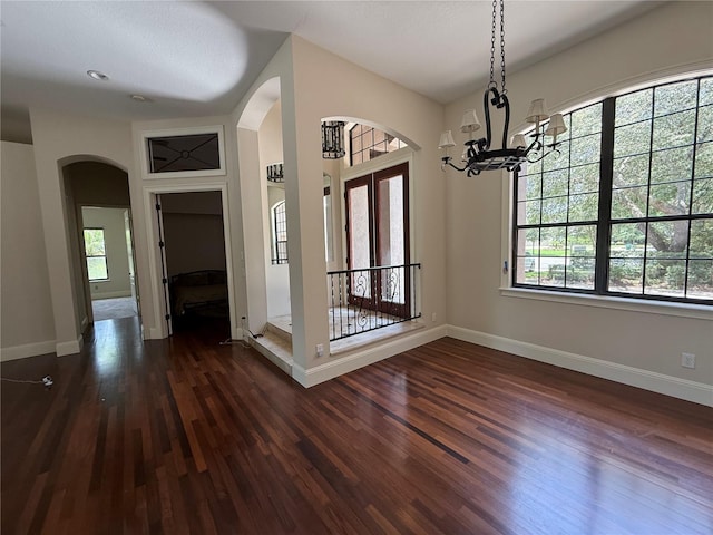 708 Palenci Ct, Winter Springs, FL 32708 - entryway featuring arched walkways, dark wood-style floors, baseboards, and a chandelier