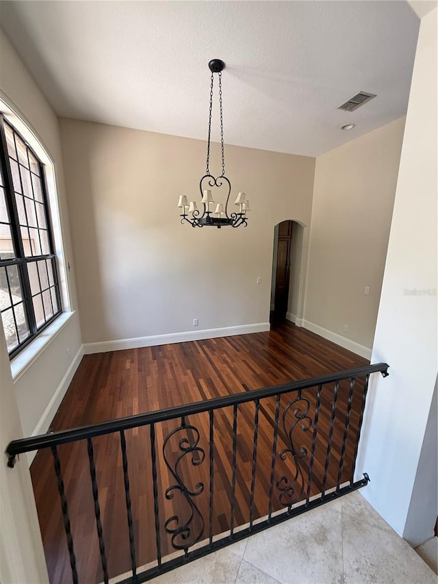 708 Palenci Ct, Winter Springs, FL 32708 - empty room featuring arched walkways, a chandelier, wood finished floors, and baseboards