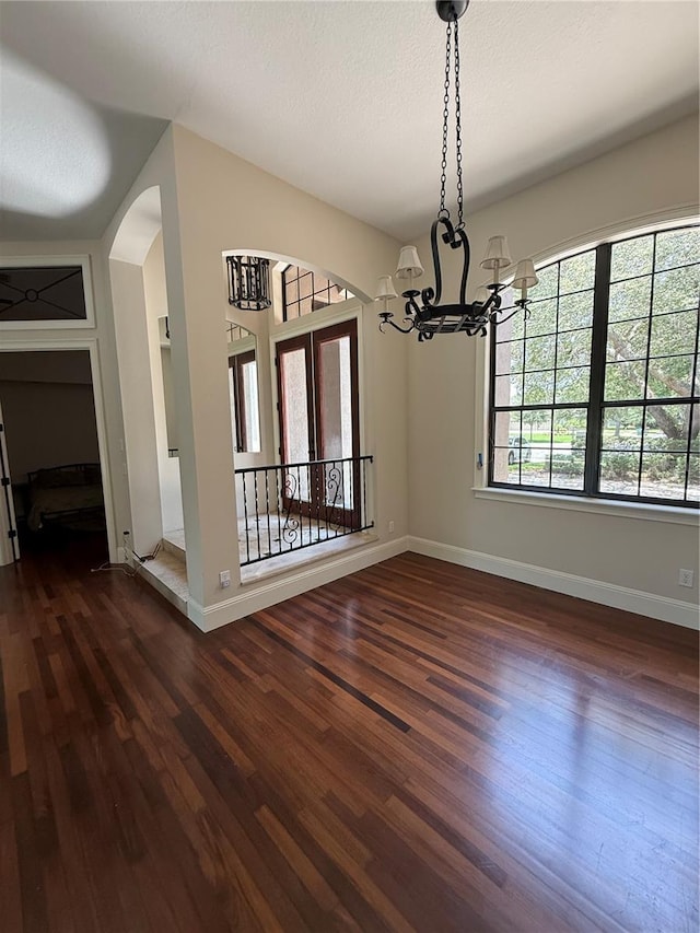 708 Palenci Ct, Winter Springs, FL 32708 - unfurnished dining area with a chandelier, dark wood finished floors, baseboards, and arched walkways
