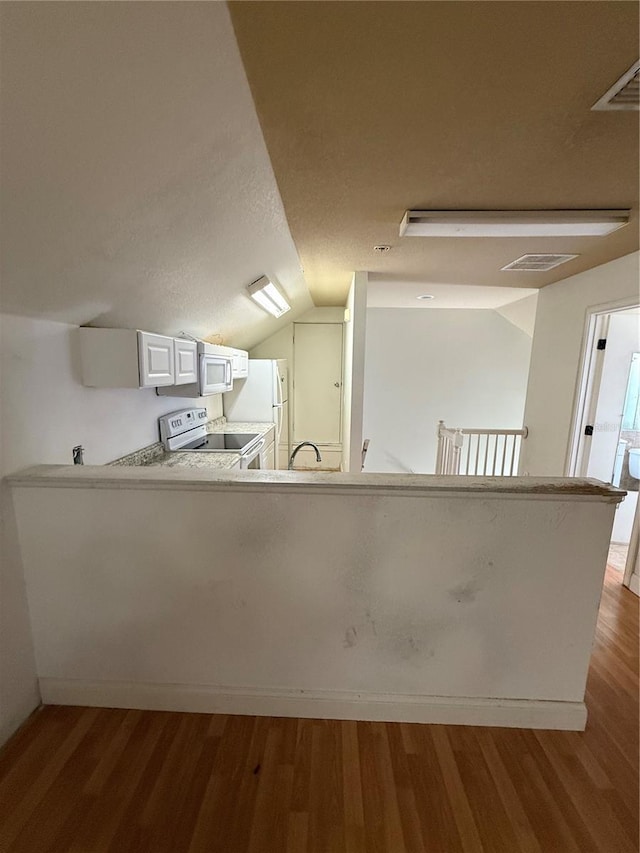 708 Palenci Ct, Winter Springs, FL 32708 - kitchen featuring white appliances, vaulted ceiling, wood finished floors, light countertops, and white cabinetry