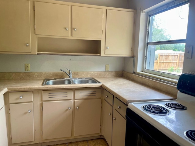 kitchen featuring electric range, open shelves, a sink, and light countertops