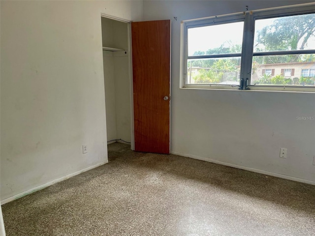 unfurnished bedroom featuring baseboards and a closet