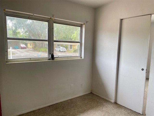 unfurnished bedroom with carpet, a closet, and baseboards