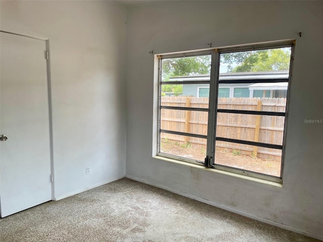 spare room featuring carpet flooring and baseboards