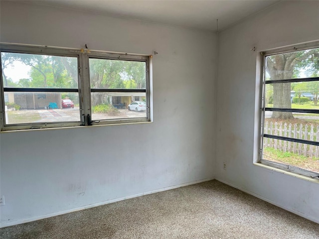 spare room with light colored carpet and baseboards