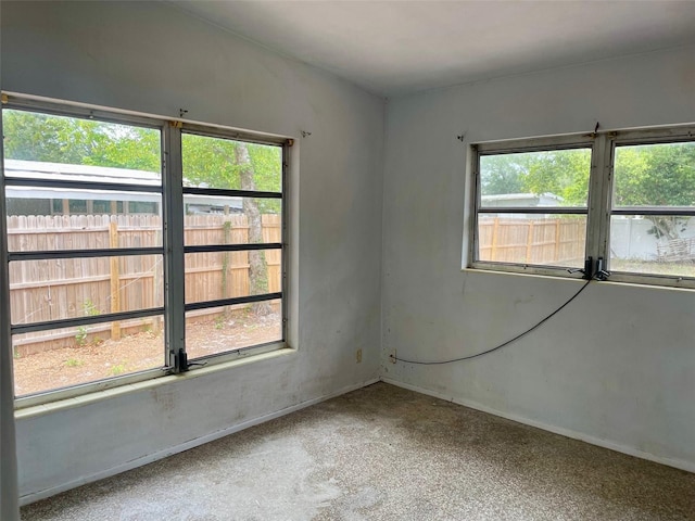 spare room featuring a healthy amount of sunlight and baseboards