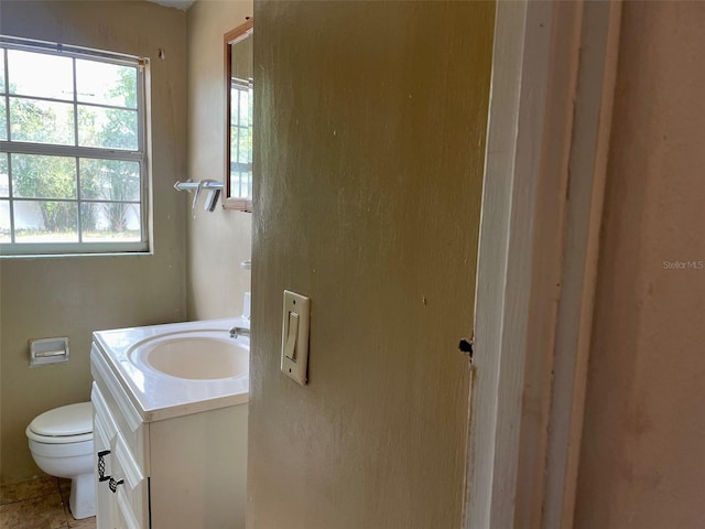bathroom with plenty of natural light, vanity, and toilet