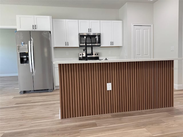 2406 SW 163rd Pl, Ocala, FL 34473 - kitchen featuring stainless steel appliances, light wood-type flooring, white cabinets, and a kitchen island with sink