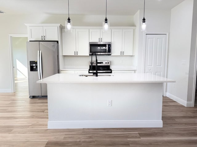 2406 SW 163rd Pl, Ocala, FL 34473 - kitchen with stainless steel appliances, a sink, a center island with sink, white cabinets, and baseboards