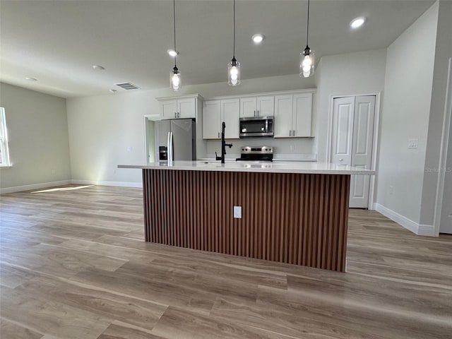 2406 SW 163rd Pl, Ocala, FL 34473 - kitchen with stainless steel appliances, baseboards, a kitchen island with sink, light countertops, and recessed lighting
