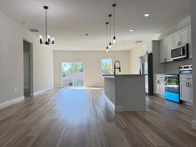 2406 SW 163rd Pl, Ocala, FL 34473 - kitchen featuring stainless steel appliances, wood finished floors, a center island with sink, baseboards, and a chandelier