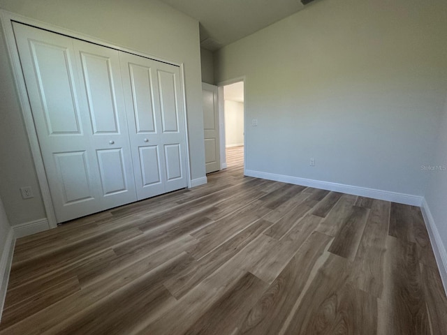 2406 SW 163rd Pl, Ocala, FL 34473 - unfurnished bedroom featuring baseboards, dark wood finished floors, and a closet