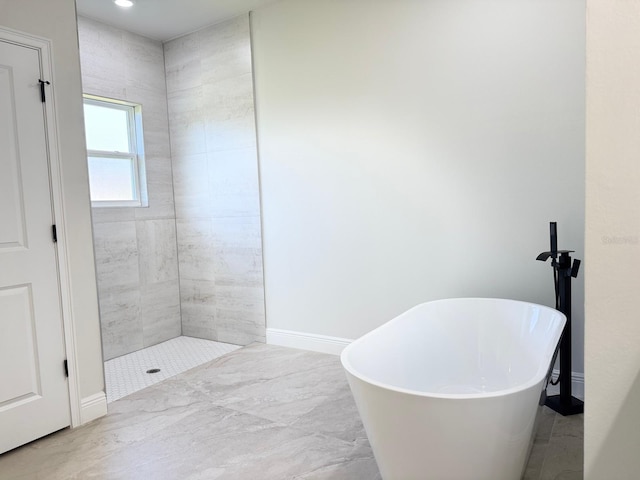 2406 SW 163rd Pl, Ocala, FL 34473 - bathroom featuring a freestanding tub, baseboards, and a tile shower