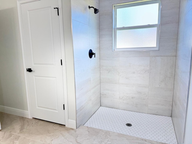 2406 SW 163rd Pl, Ocala, FL 34473 - bathroom with a tile shower, marble look tiles, and baseboards