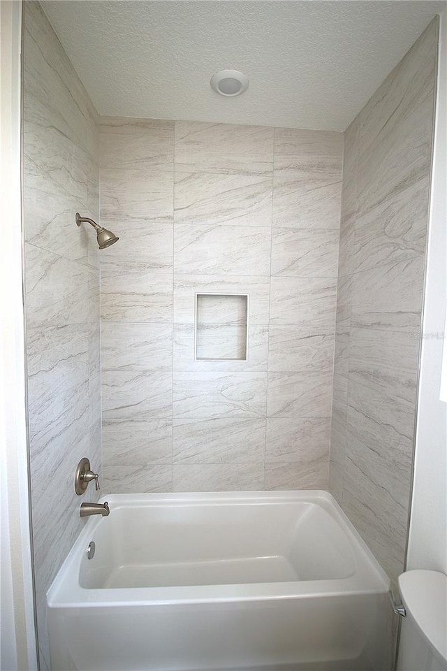 8990 Glenarm Way, Weeki Wachee, FL 34613 - bathroom featuring toilet, a textured ceiling, and shower / bathtub combination