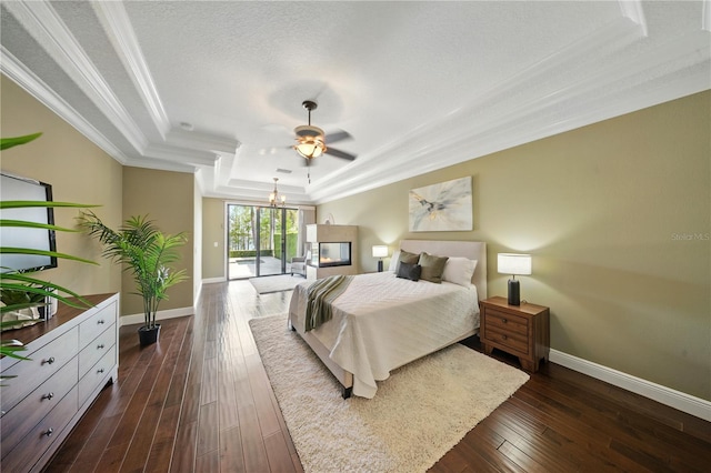 7624 Pointe Venezia Dr, Orlando, FL 32836 - bedroom with a tray ceiling, ornamental molding, dark wood-style floors, ceiling fan, and a chandelier